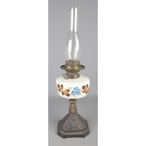 286 - A Victorian Wright and Butler oil lamp on floral cast iron base with floral hand painted reservoir.