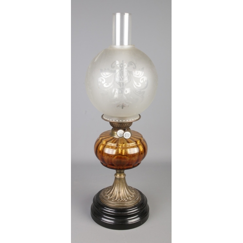 288 - A brass and glass oil lamp featuring amber glass reservoir and circular etched shade. Approx. height... 