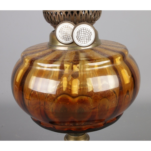 288 - A brass and glass oil lamp featuring amber glass reservoir and circular etched shade. Approx. height... 