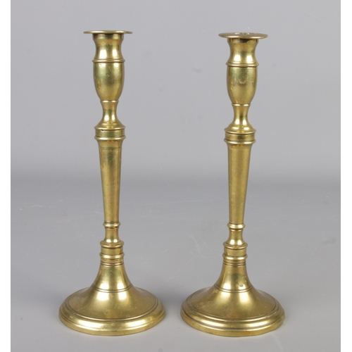 291 - A pair of 19th century brass candlesticks. Height 24.5cm.