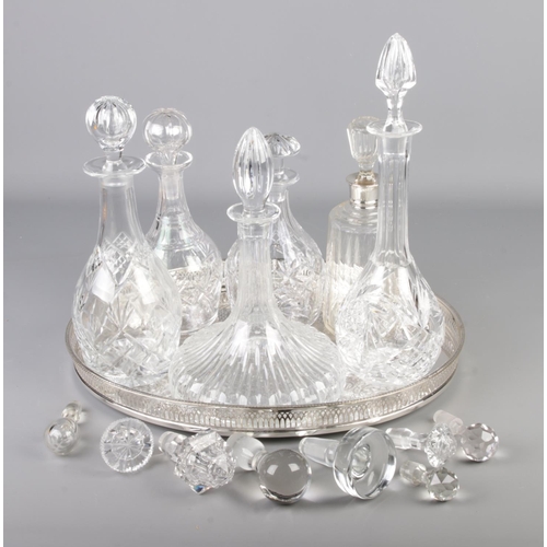 280 - Six cut glass decanters one having a silver top all with stoppers on a silver plate tray with a quan... 