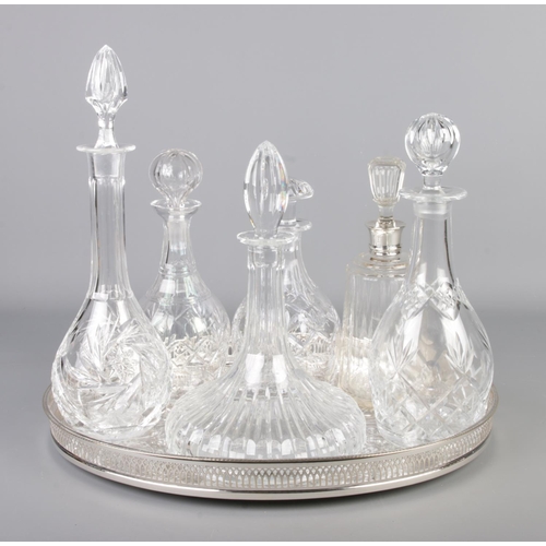 280 - Six cut glass decanters one having a silver top all with stoppers on a silver plate tray with a quan... 