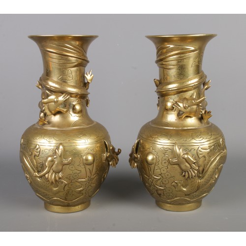 266 - A pair of early Twentieth Century Chinese polished brass vases decorated with coiled dragons. Bearin... 