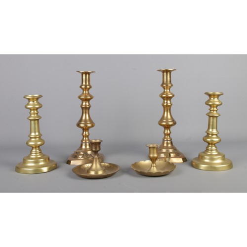 271 - Two pairs of brass candlesticks, along with two brass chambersticks.