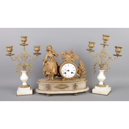 128 - An antique French gilt bronze figural mantel clock garniture, with two bronze candelabra. The clock ... 