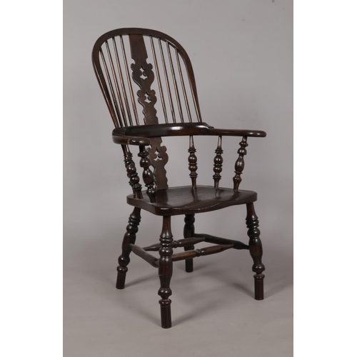 600 - A 19th century ash/elm Windsor arm chair. With pad arms and pierced splat back. Height of back 115cm... 