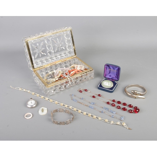 154 - A glass jewellery box containing an assortment of costume jewellery. To include shell necklace with ... 