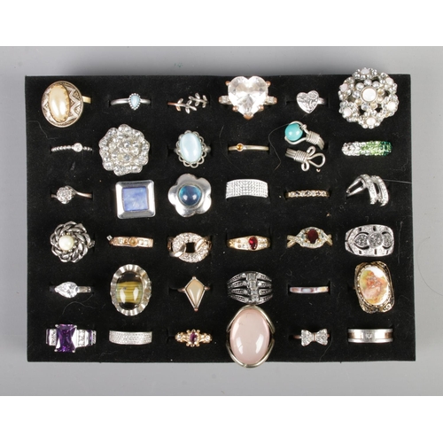 160 - A collection of mostly costume jewellery rings to include three silver rings. Includes floral, heart... 