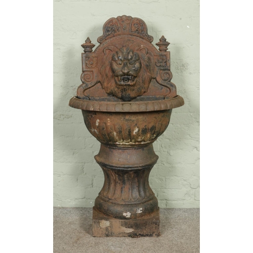 A large cast iron flat back lion mask water feature, with half-urn ...
