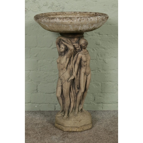 376 - A large cast concrete bird bath, with figural pillar on stepped octagonal base. Height: 78cm.