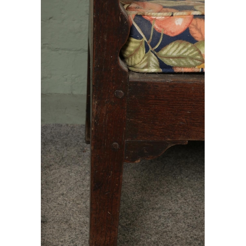 601 - An 18th century oak settle or hall bench with moulded cresting rail over five fielded panelled back.... 