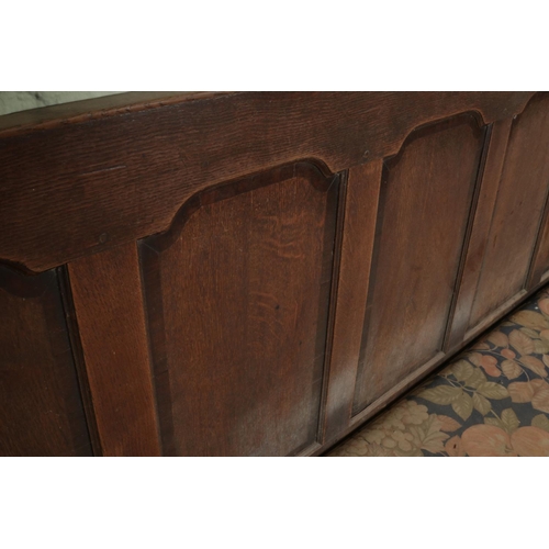 601 - An 18th century oak settle or hall bench with moulded cresting rail over five fielded panelled back.... 