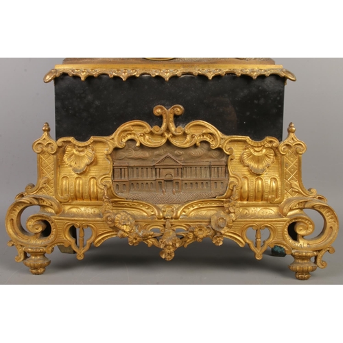 13 - An antique French bronze and slate mantel clock, with a bronze figure seated beside pillars and scro... 