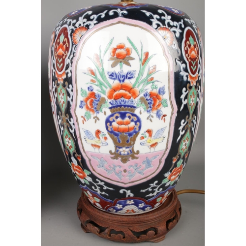 52 - A pair of Chinese Imari lidded vases converted to table lamps raised on hardwood stands. Approx. hei... 