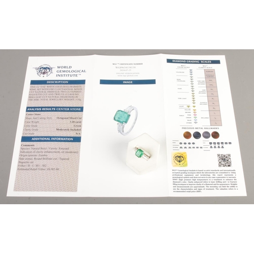 125 - An 18ct white gold emerald and diamond ring. Set with an octagonal cut emerald, flanked by two bague... 