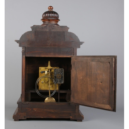 34 - An antique German Junghans carved oak mantel clock, featuring deep relief carvings, circular finial ... 