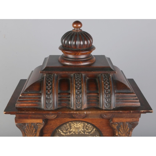 34 - An antique German Junghans carved oak mantel clock, featuring deep relief carvings, circular finial ... 