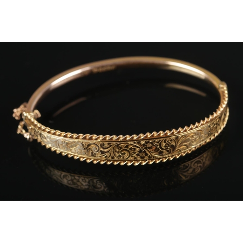 A 9ct gold bracelet with scrolled engraving.

6.64g