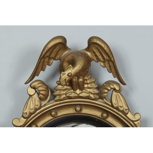 219 - An antique Regency style giltwood convex wall mirror. With carved eagle and ball frieze. Length 91cm... 