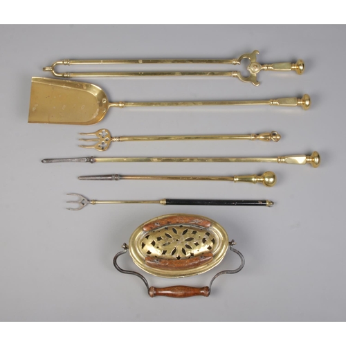 126 - An antique brass carriage foot warmer, along with a collection of brass fireside tools.