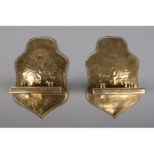 128 - A pair of brass twin candle wall sconces, both decorated with heraldic crests. Height 30cm.