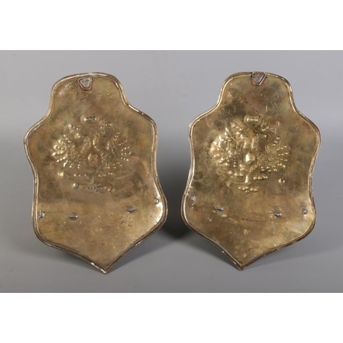 128 - A pair of brass twin candle wall sconces, both decorated with heraldic crests. Height 30cm.