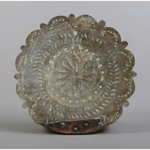 131 - An 18th century brass candleholder. With three candle sockets and repousse and punchwork decoration ... 