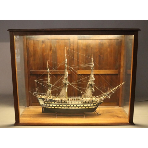 140 - A large hand built model of a war ship, based on HMS Victory, encased within a mahogany and glass il... 