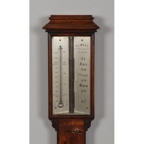 216 - An oak stick barometer by FL West. Length 97cm.