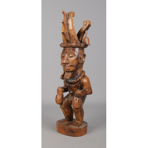 75 - A Nias Island carved wooden statue, ancestor carrying two heads. Height 35.5cm.