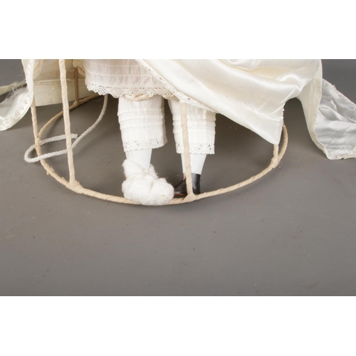 25 - A vintage bisque Empress Eugenie doll head and shoulders raised in a framed period style dress. Poss... 