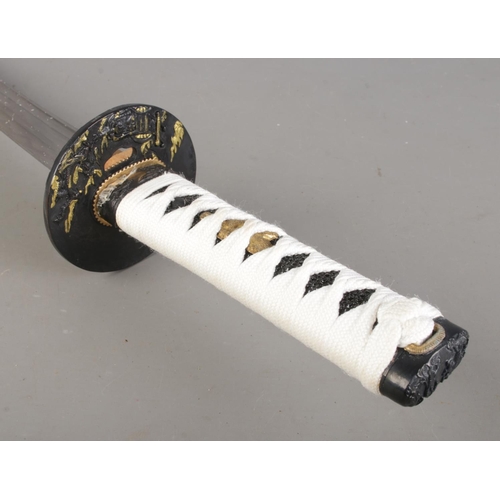 76 - A modern samurai sword in sheath mounted on stand, together with a set of nunchucks. Blade length of... 