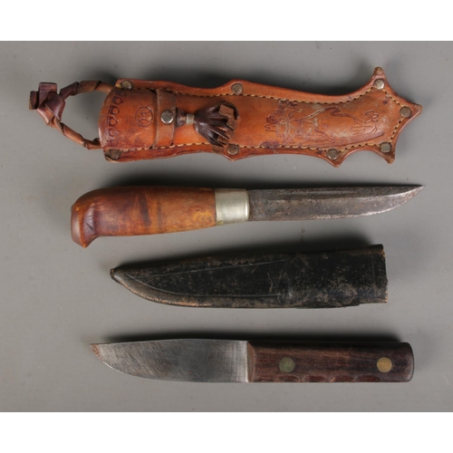 78 - A Finnish Puukko knife with engraved blade and decorated leather scabbard featuring a figure sleddin... 
