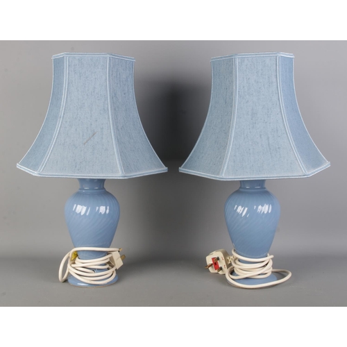 118 - A pair of 'St Michael' baby blue ceramic table lamps; both with shades.