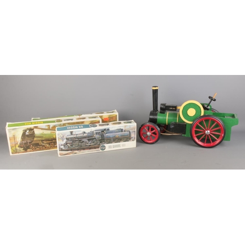 96 - An apprentice small wooden handcrafted painted train model  alongside three boxed Airfix train model... 