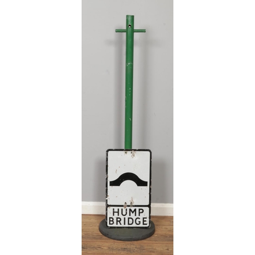 A vintage aluminium road sign for 'Hump Bridge', alongside a metal pole ...