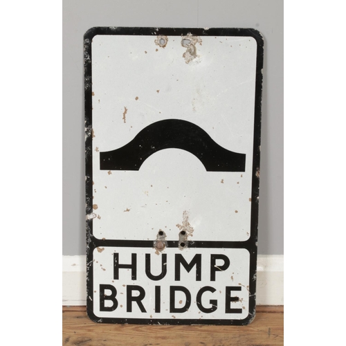 A vintage aluminium road sign for 'Hump Bridge', alongside a metal pole ...