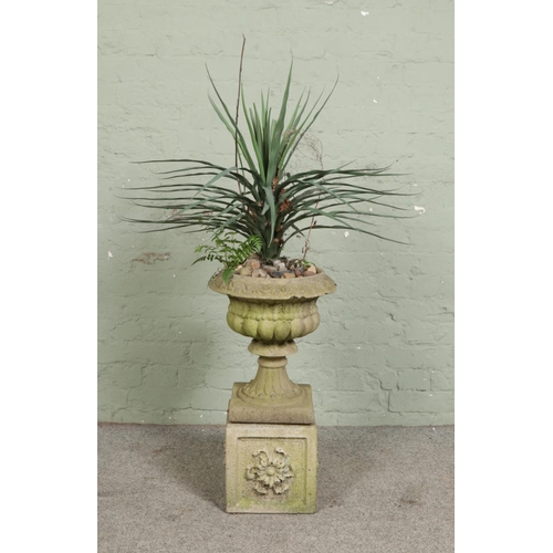 381 - A small composition stone garden urn shaped planter on square pedestal.

Hx69cm