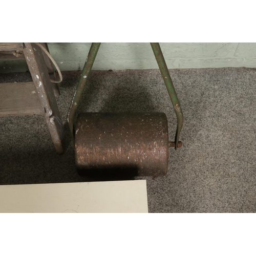 392 - A heavy metal garden roller alongside a bespoke tool box and stepladders.