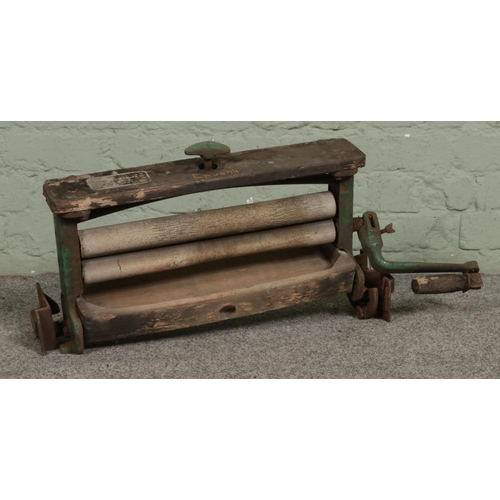 395 - A vintage Ewbank cast and wooden mangle. L65cm.