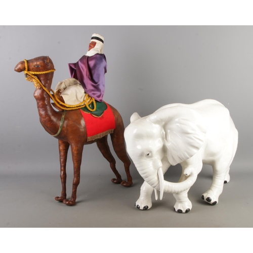 74 - A large white Italian ceramic model of an elephant, together with a leather wrapped model of a camel... 
