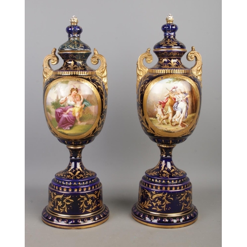 489 - A pair of early Twentieth Century Austrian twin handled lidded urns, in cobalt blue with gilt highli... 