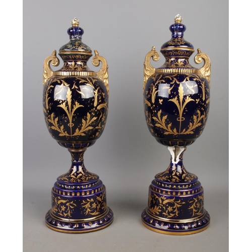 489 - A pair of early Twentieth Century Austrian twin handled lidded urns, in cobalt blue with gilt highli... 