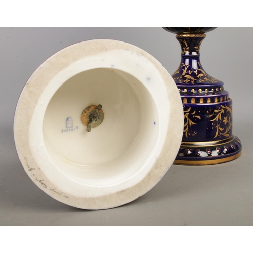 489 - A pair of early Twentieth Century Austrian twin handled lidded urns, in cobalt blue with gilt highli... 