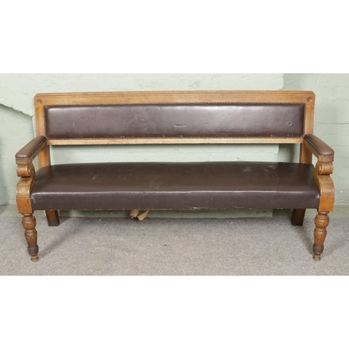 543 - A large oak carved hall bench with leather buttoned upholstery and detailed scrolled front legs. L17... 