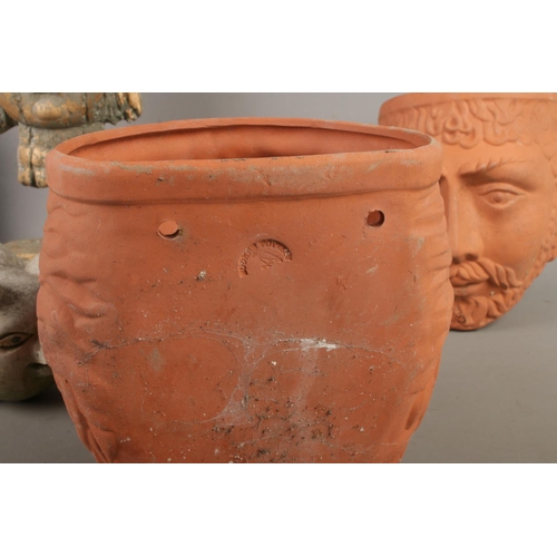 135 - Two Rookes Pottery terracotta wall planters in the shape of heads alongside three garden ornaments i... 