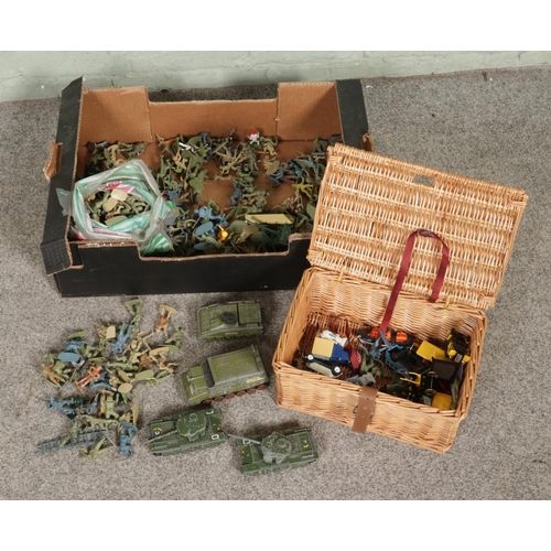 141 - A box of assorted composite toy soldiers along with a collection of Dinky diecast miliary vehicles.