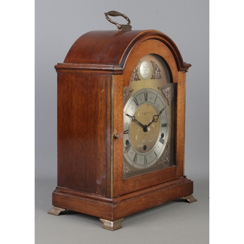 A mahogany cased Elliot bracket clock in the Georgian style, with arched dial signed 'Tempus Fugit'. The silvered chapter ring having Roman Numeral markers, bearing retailer mark for Owen & Robinson Ltd, Leeds. Chiming on Westminster/Whittington chimes. Height: 32.5cm. With key.