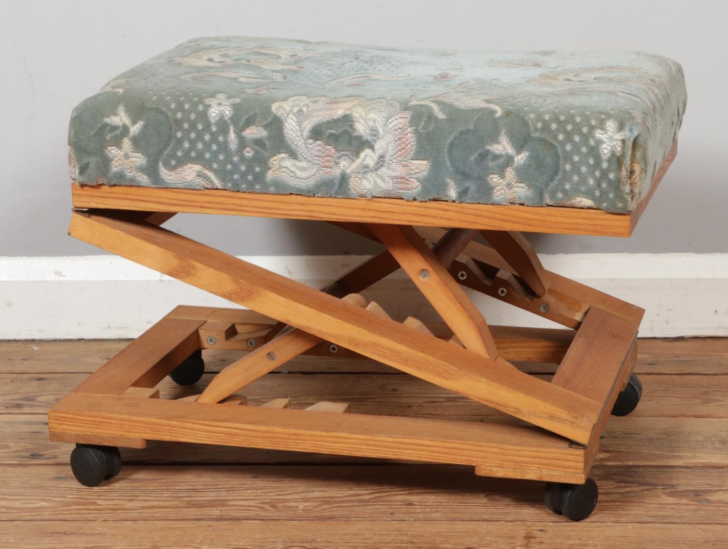 An ash and beech upholstered adjustable foot stool with castors. L52cm ...