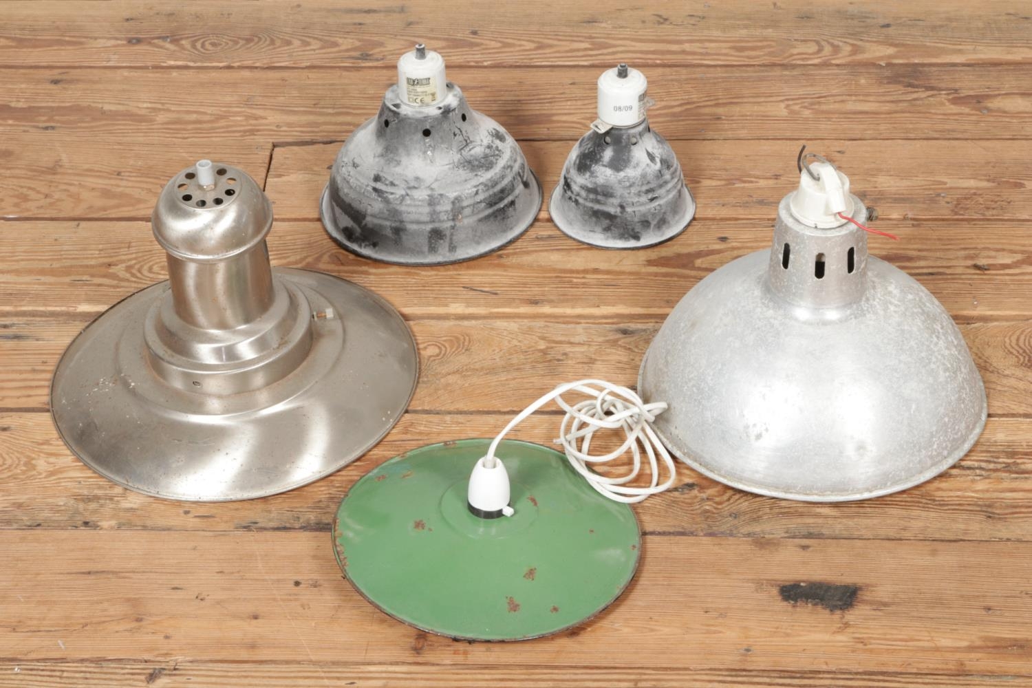 Five industrial type light shades including a green enamelled example